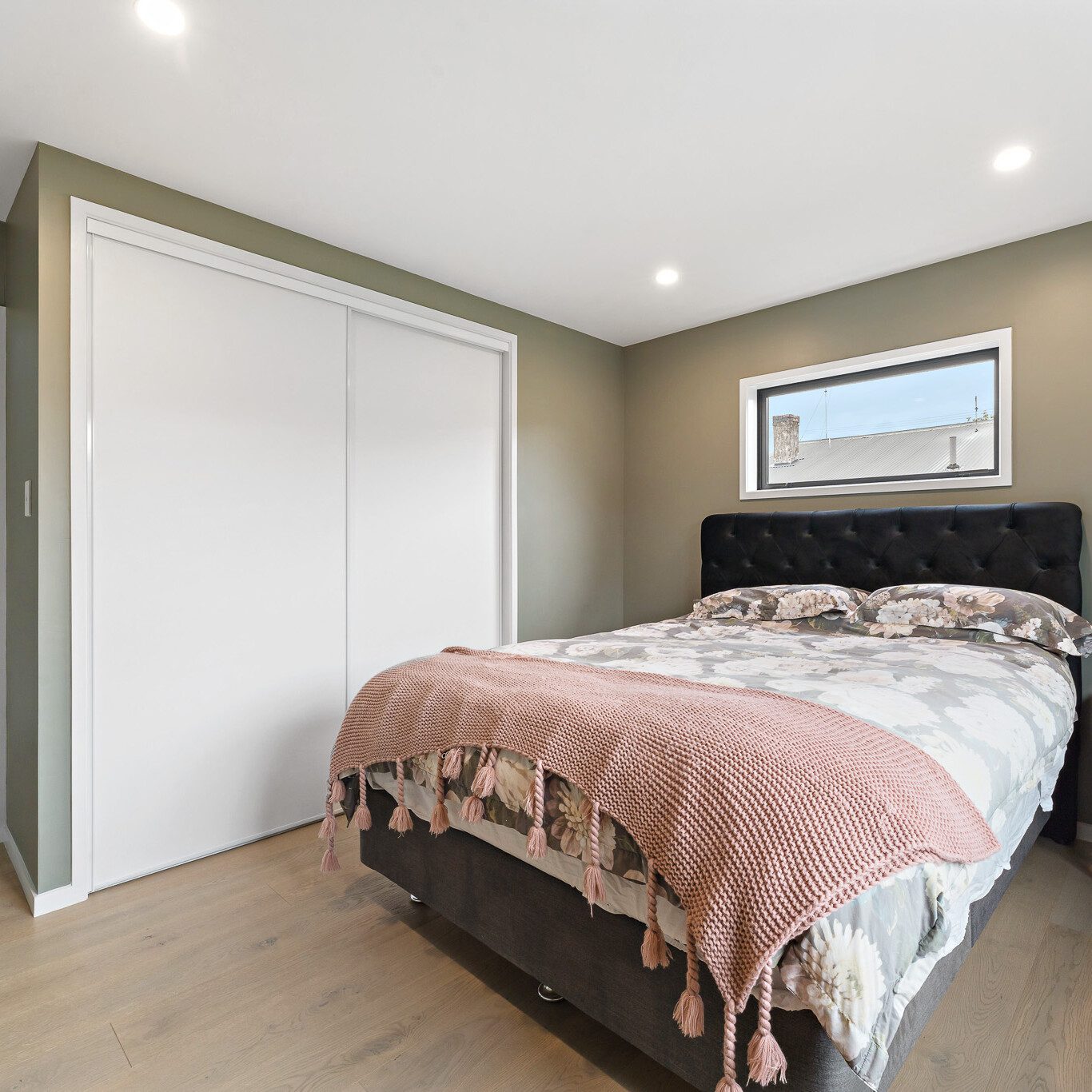 A bedroom with white sliding wardrobe doors